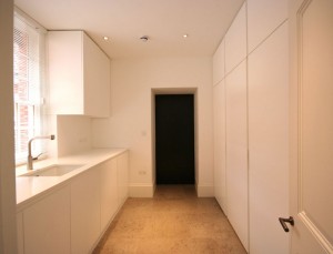 Utility Room with spray-painted cabinets, panels and secret ‘jib door’.  Corian worksurfaces.