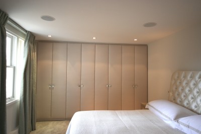 Bedroom Wardrobes with American Walnut interior and fabric covered doors.  ‘Jib’ door through to en-suite bathroom.