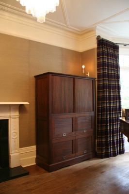 Media cabinet with television concealed behind tambour slatted door. Made from reclaimed Iroko.